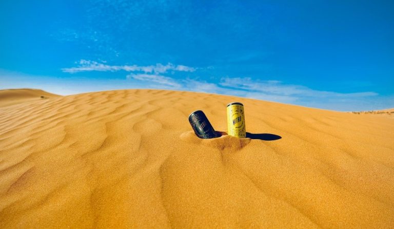 Two cans of RTD coffee in a desert.