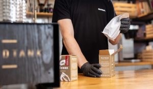 A roaster preparing the best coffee for cold brew next to a Hardtank machine.