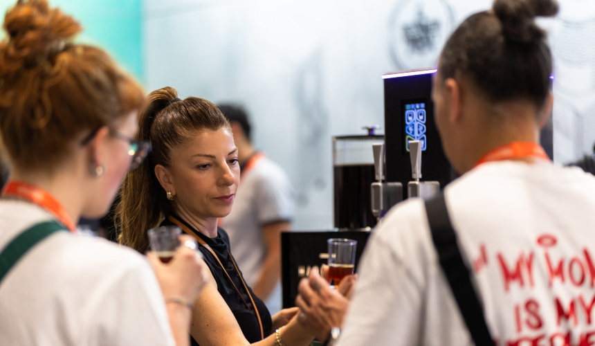Customers being served cold brew from a nitro cold brew tap.