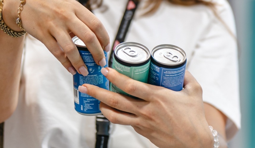 A customer holding three RTD cans.