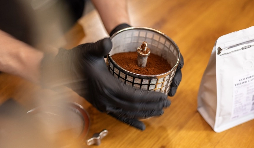 The filter basket of a Hardtank ready to drink coffee machine with ground coffee inside.