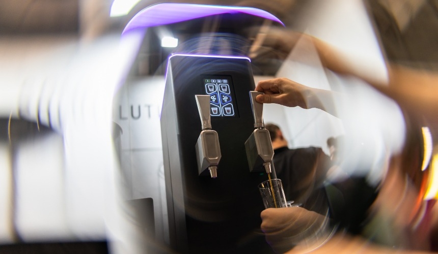 Pouring a drink from nitro cold brew coffee equipment.