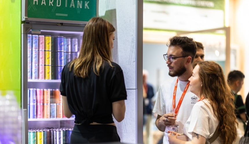 Three people stood around a fridge containing drinks from private label energy drink manufacturers.