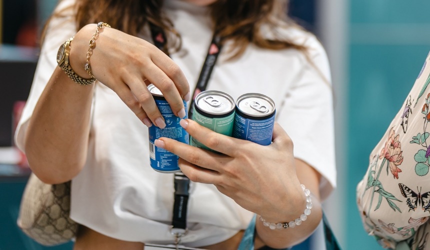 Should you offer private label matcha to your customers? 2 A person holding RTD cans of private label matcha and other drinks.