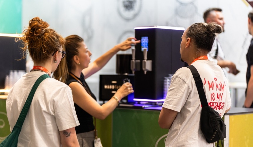 How efficient is a cold brew coffee tap system compared to traditional methods? 3 A barista pouring from a cold brew coffee tap system while customers watch.