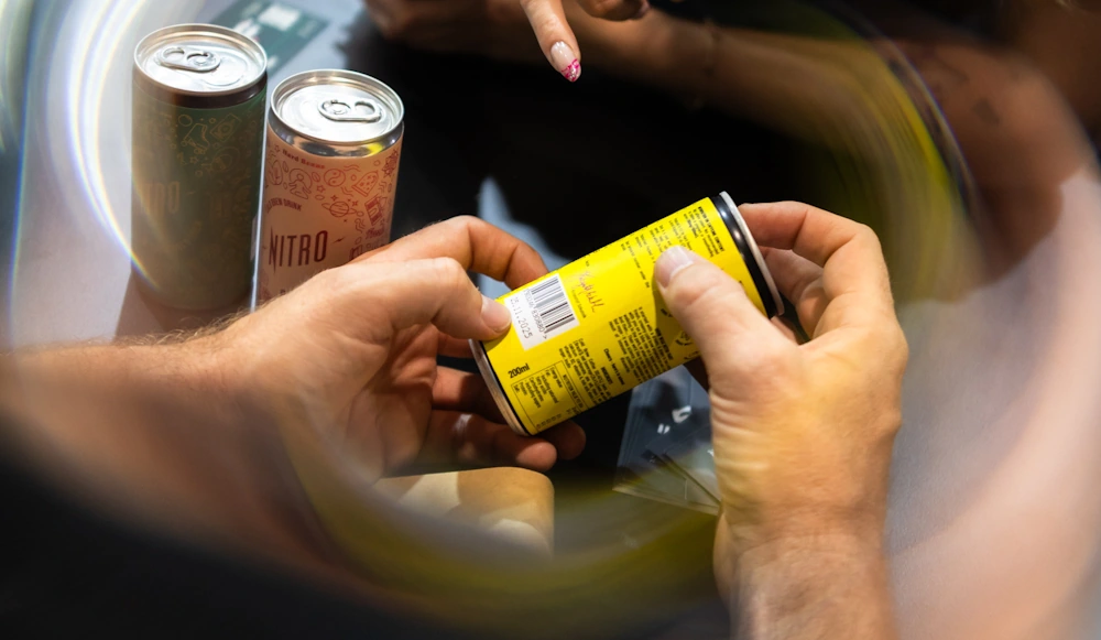 A person holds a yellow Hardtank cold brew can.