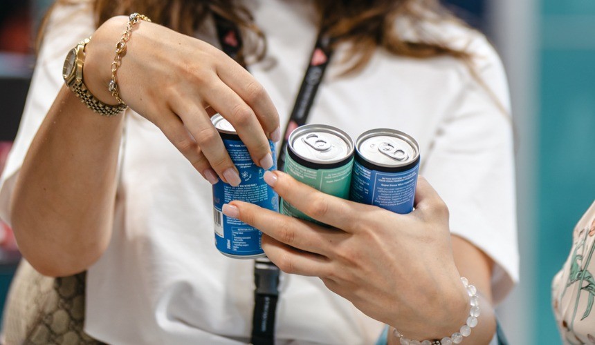 A person holding three cans of commercial cold brew.